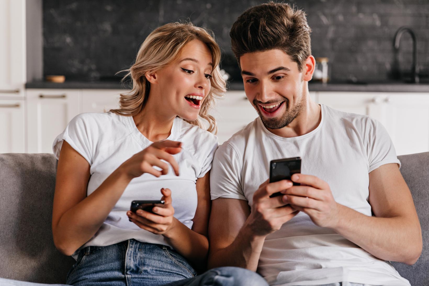 Picture 20220930111932-7357-smiling-couple-sitting-couch-with-phones-adorable-young-woman-holding-smartphone  format jpg